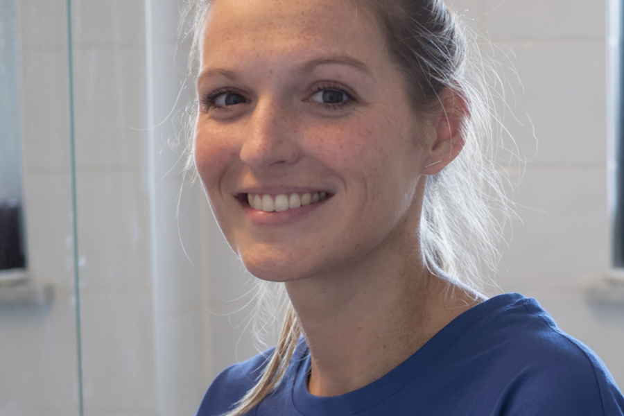 Lächelnde HappyMaids Mitarbeiterin im Porträt mit blauem T‑Shirt